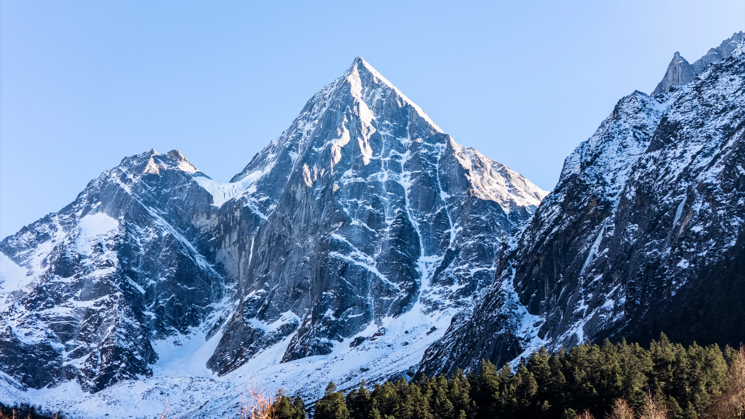 蓝天下的四姑娘山幺妹峰，积雪覆盖陡峭的山脊